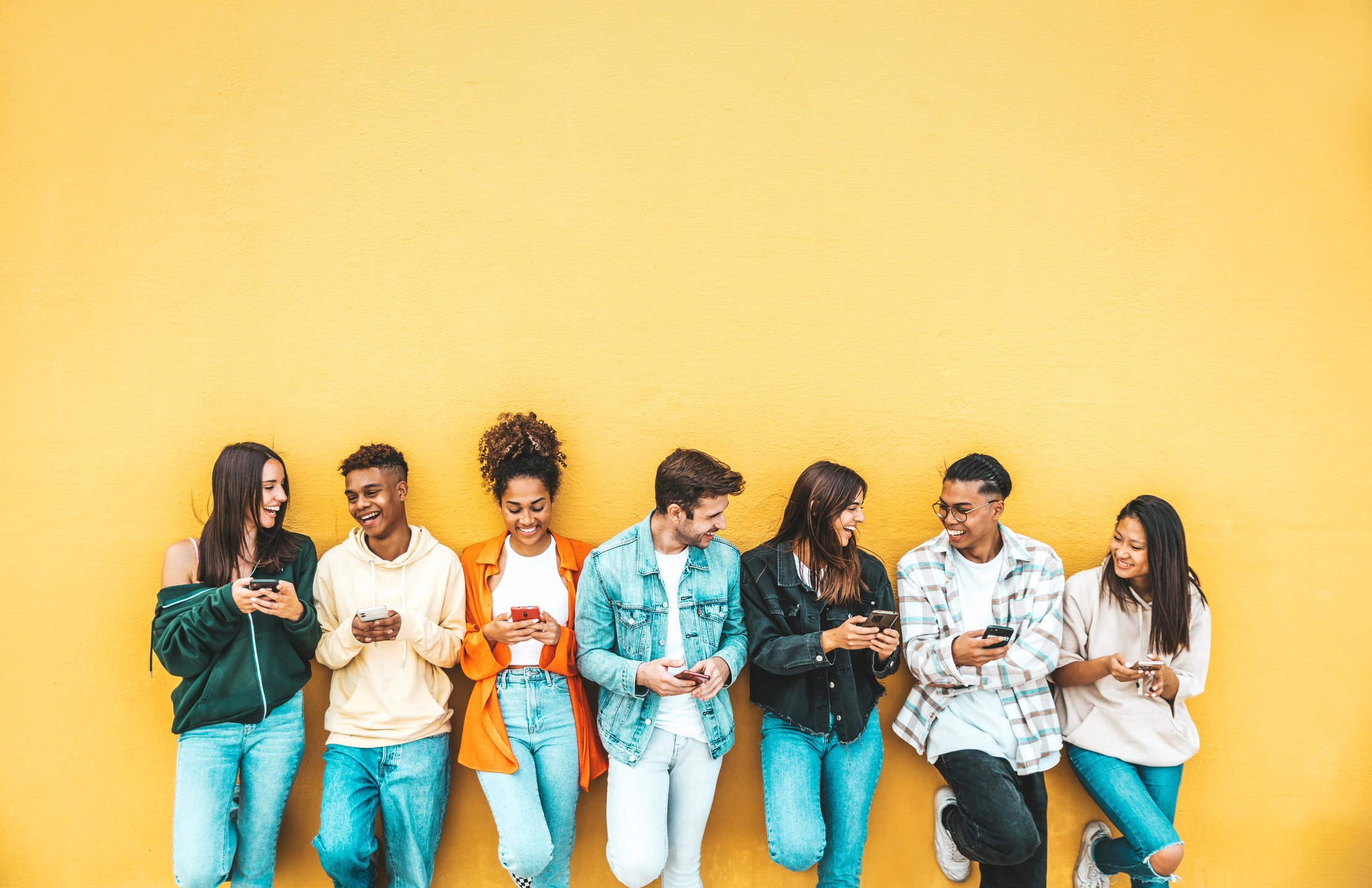 Group of young people using smart mobile phone device outside -